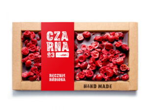 Ręcznie robiona czekolada z suszonymi wiśniami w kartonowym opakowaniu z czerwonym akcentem.