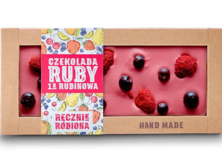 Różowa czekolada Ruby z malinami i owocami, w kartonowym opakowaniu z napisem Czekolada Ruby - ręcznie robiona.