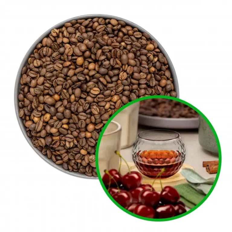 Miska pełna ziaren kawy i szkło z napojem obok świeżych wiśni na tle kuchennym.