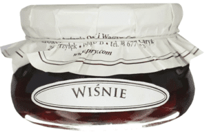 Słoik z wiśniami w syropie z białą etykietą i zakrętką, etykieta z napisem WIŚNIE.