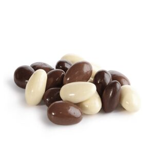 Kolorowe draże w czekoladzie: mlecznej, ciemnej i białej, ułożone w stos na białym tle.