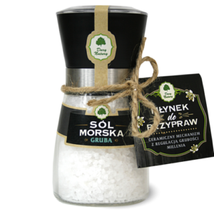 Gruboziarnista sól morska w młynku z regulacją mielenia, marki Dary Natury, ozdobionym etykietą i sznurkiem.