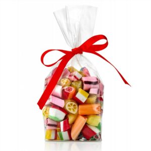 Kolorowe cukierki w przezroczystej torebce, przewiązanej czerwoną wstążką, idealne na prezent.