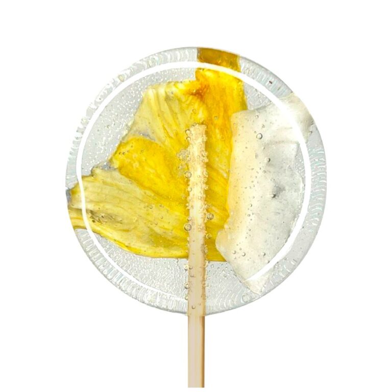 Lizak z zatopionym żółtym i białym kwiatem, na przezroczystym tle, z bąbelkami powietrza.