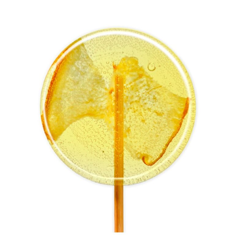 Lizak z przezroczystym, żółtym cukrem i kawałkiem owocu w środku na białym tle.