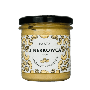 Słoik pasty z nerkowców 100% naturalnych orzechów z czarną zakrętką i etykietą z rysunkami nerkowców.