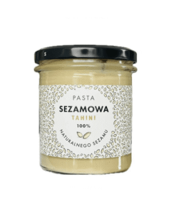 Słoik pasty sezamowej tahini 100% z naturalnego sezamu, z czarną nakrętką i dekoracyjną etykietą.