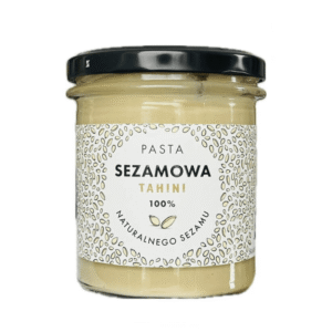 Słoik pasty sezamowej tahini 100% z naturalnego sezamu, z czarną nakrętką i dekoracyjną etykietą.